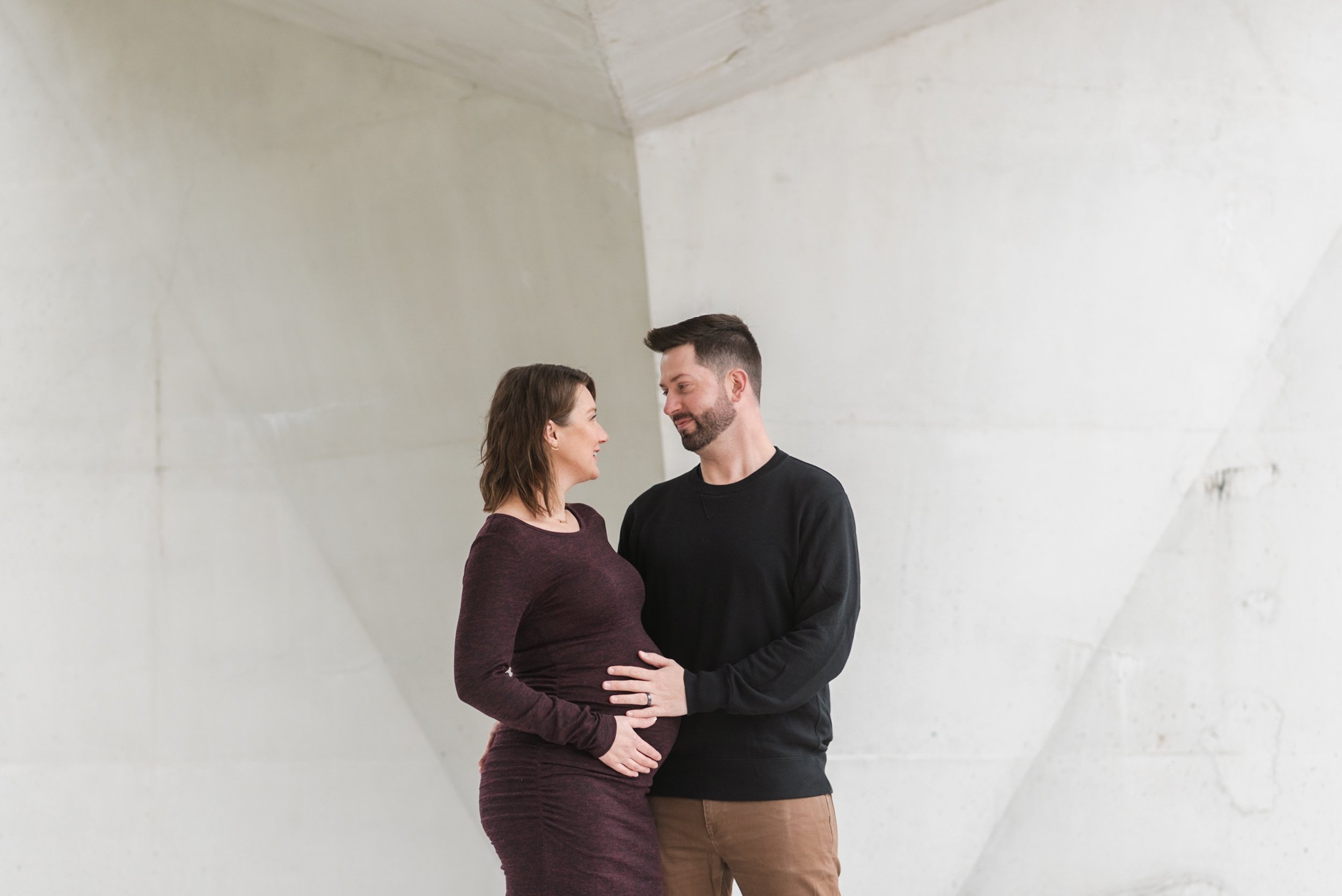 Pregnant woman with husband against white background