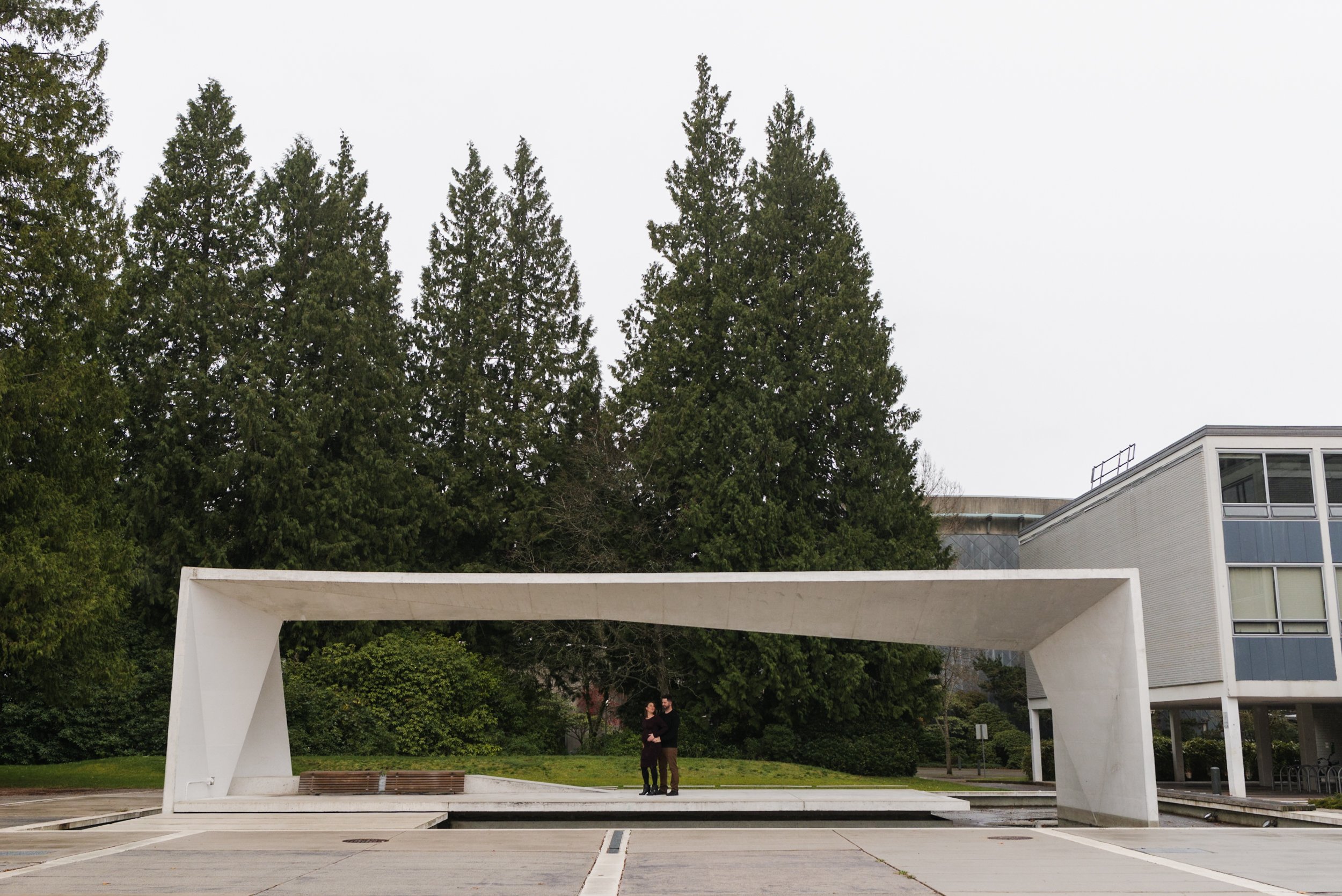 Pregnant woman with husband standing in architectural structure