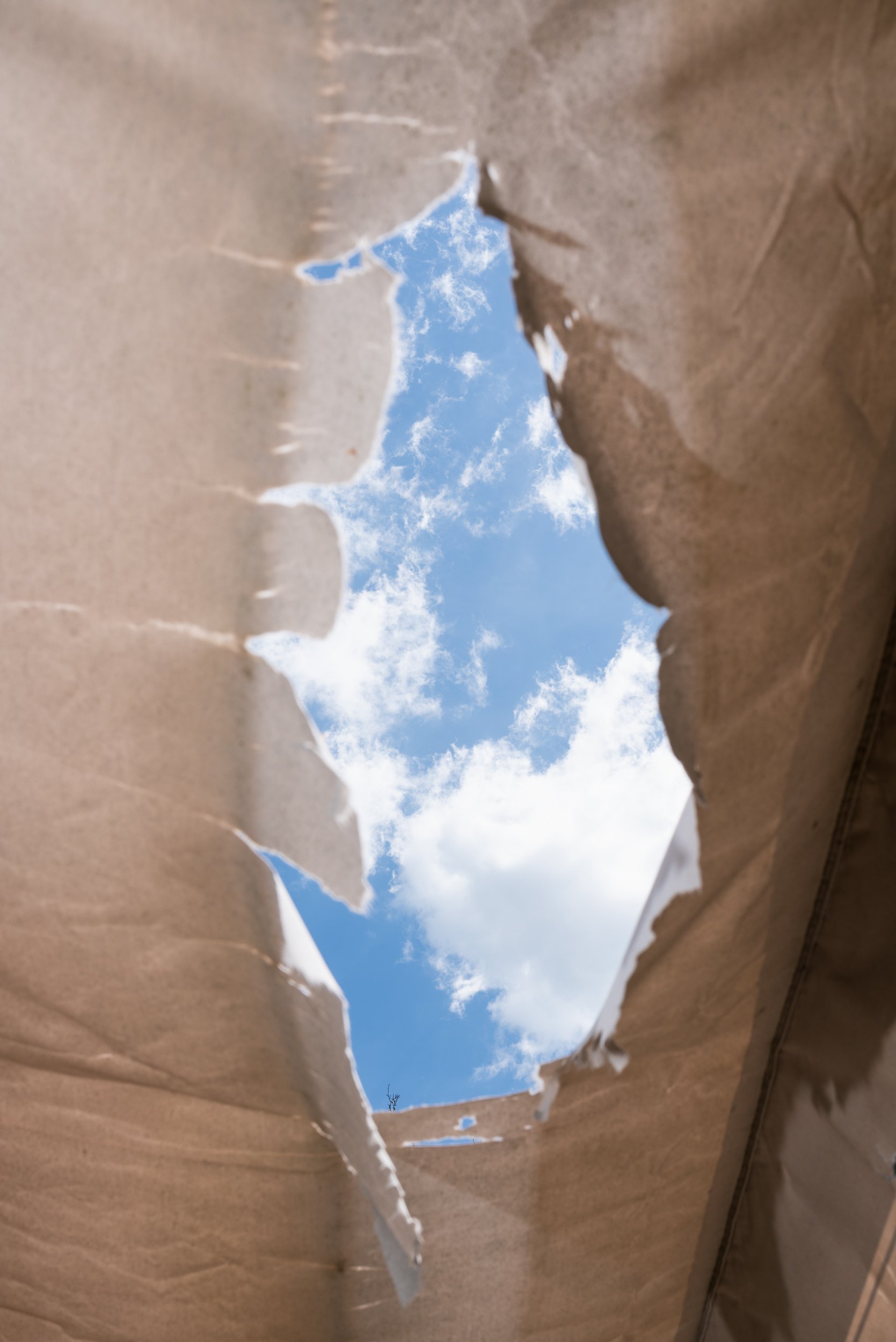 Sky through ripped awning