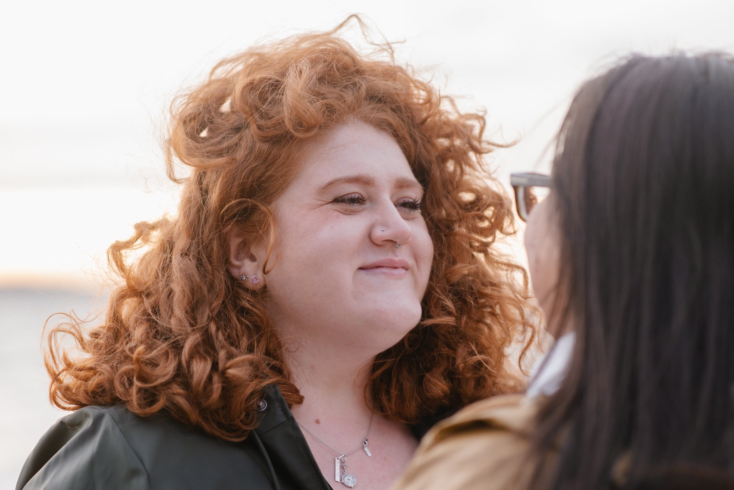 Woman with red curly hair smiling at partner lovingly