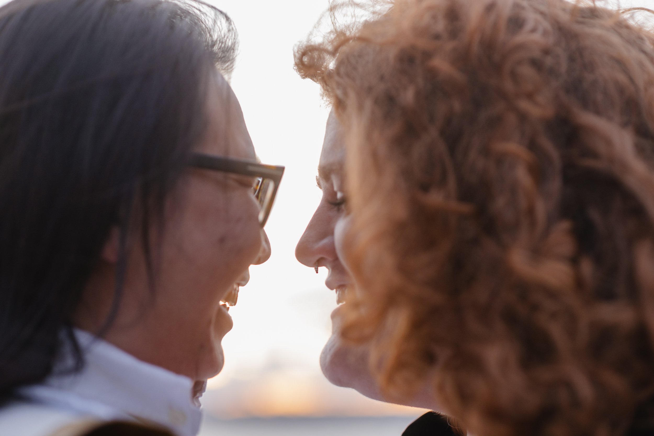 Couple facing each other with sunset behind them