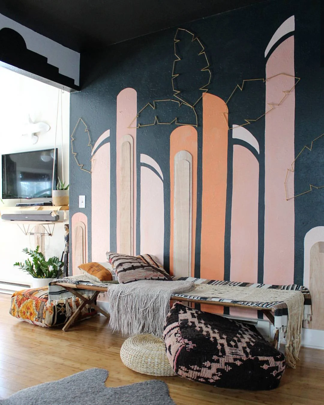 A fun and colorful mural with the addition of plywood shapes and palm leaves made of yarn wrapped around nails.