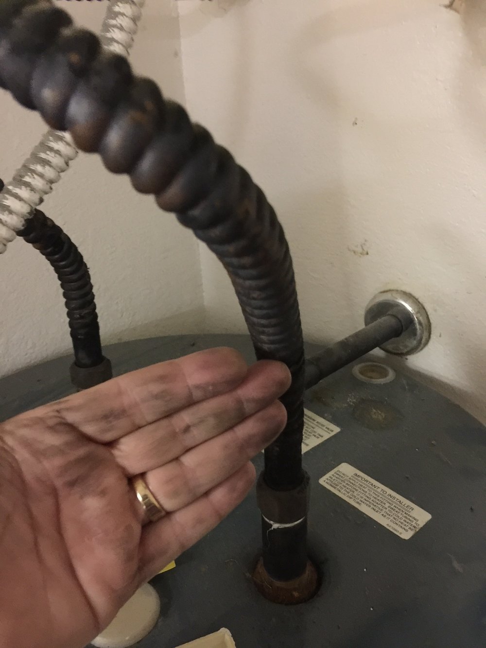 Black Rubbed Off on Hand, Hot Water Heater Copper Plumbing Line Due to Chinese Drywall Found During Home Inspection Houston Texas 