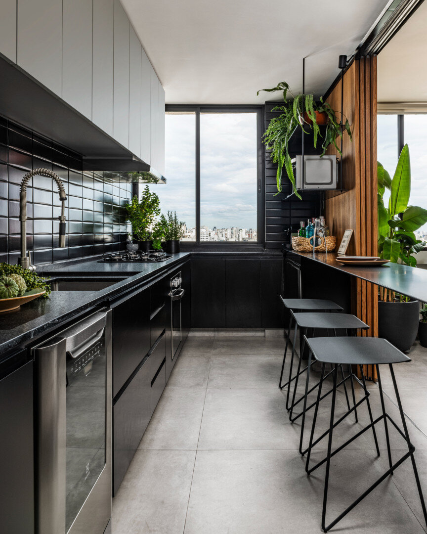 Apartamento 222 &ndash; Todo o design minimalista do projeto est&aacute; presente na marcenaria planejada da cozinha. Os equipamentos s&atilde;o embutidos, os arm&aacute;rios funcionais e os tons de preto d&atilde;o continuidade a paleta de cores s&o