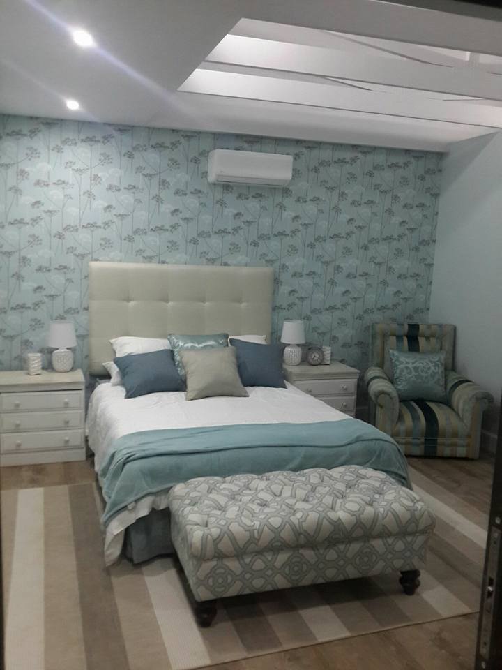 Here I reupholstered the ottoman & chair as well as repainted the bedside tables. Splurged on the fabric for ottoman and chair. The wallpaper is a beautiful feature in this tranquil room.