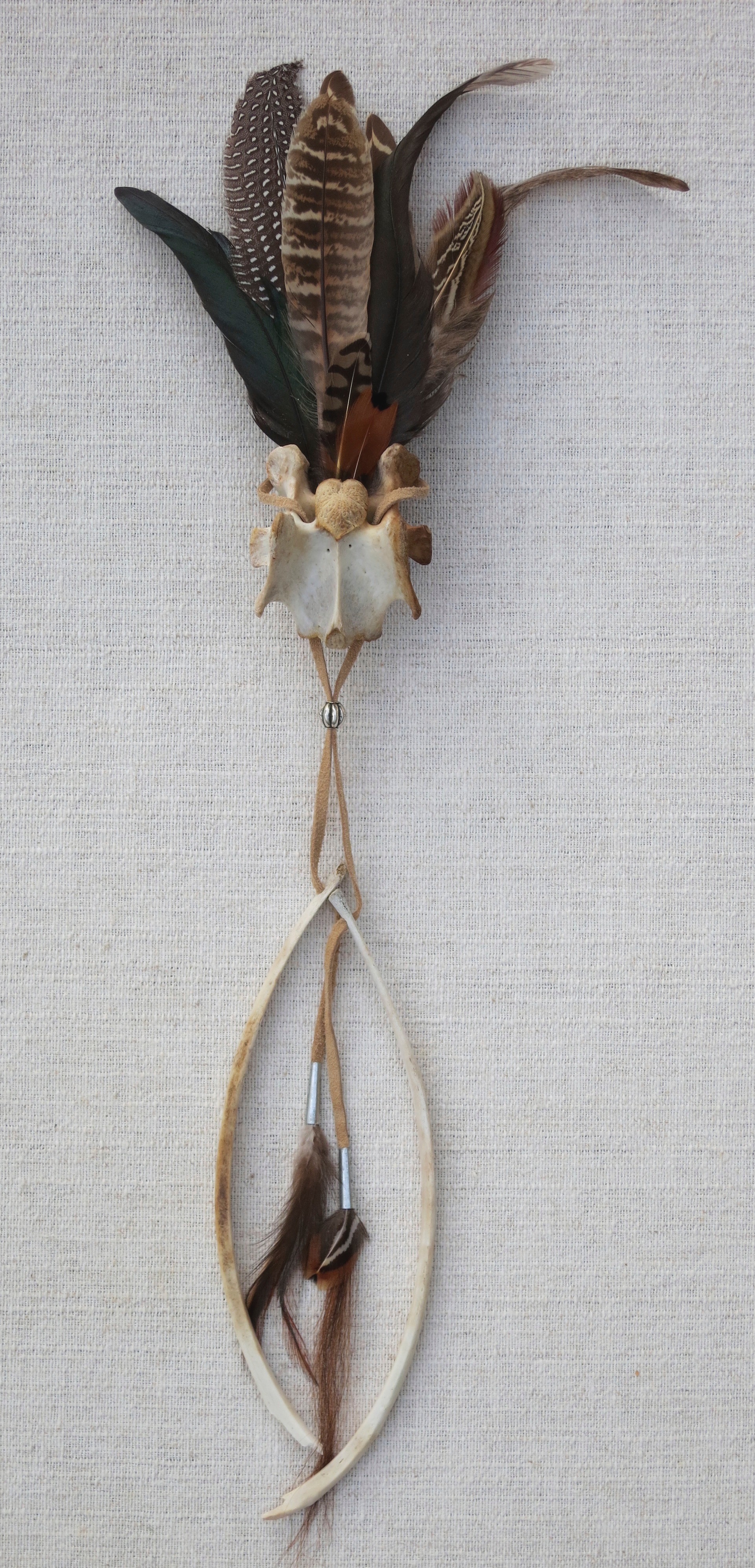 Tribute #9 2014 21" Found feathers, deer bones assembled with leather, tin and horsehair.