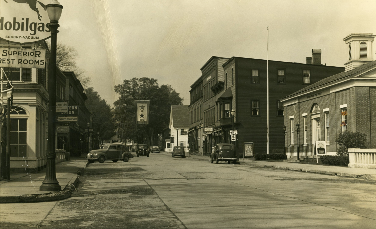 Stepping back outside, across the street, notice the recently-built post office that was completed in the late 1930s. Also notice the World War II "Star" banner that is hanging across the street.