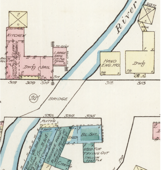 Detail from an 1885 Sanborn Map. On this map, the Engine House (abbreviated “Eng.Ho”), is shown in yellow. It is located between the jail and a dwelling house and hangs over the river.