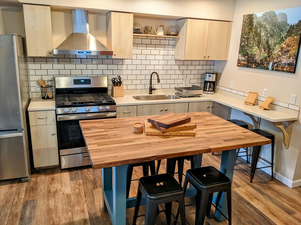 The well-equipped kitchen with a beautiful walnut slab island that serves multiple functions as additional counter space, dining table, and hangout area.