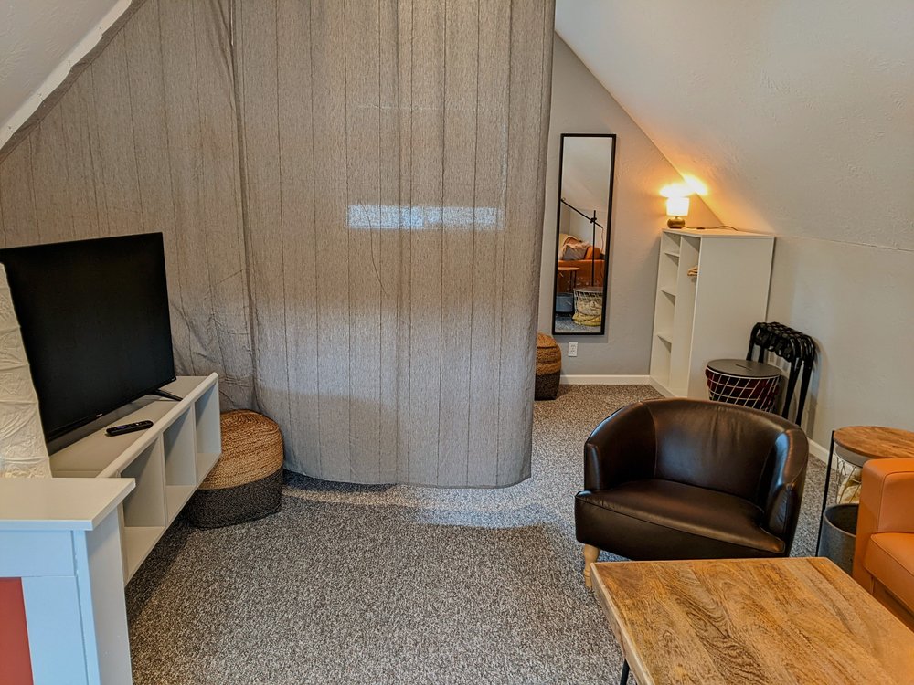 Looking from the lounge area towards the bedroom with bedroom curtain divider closed for separation and privacy.