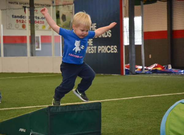 Boy jumping off ledge for obstacle course