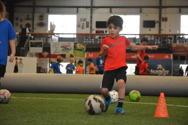 Boy in Red Shirt Dribbles Soccer Ball
