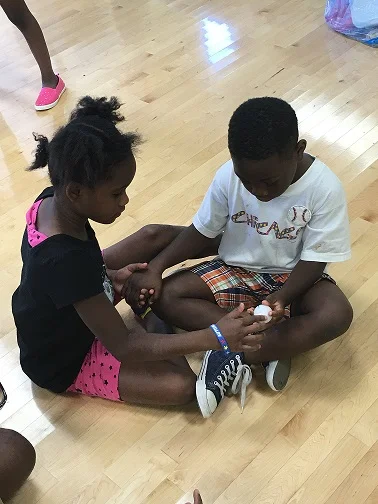 STUDENTS AT SOUTHEAST YMCA DEMONSTRATING A CLOSED CIRCUIT USING JUST THEIR HANDS AND THESE FUN ENERGY BALLS.
