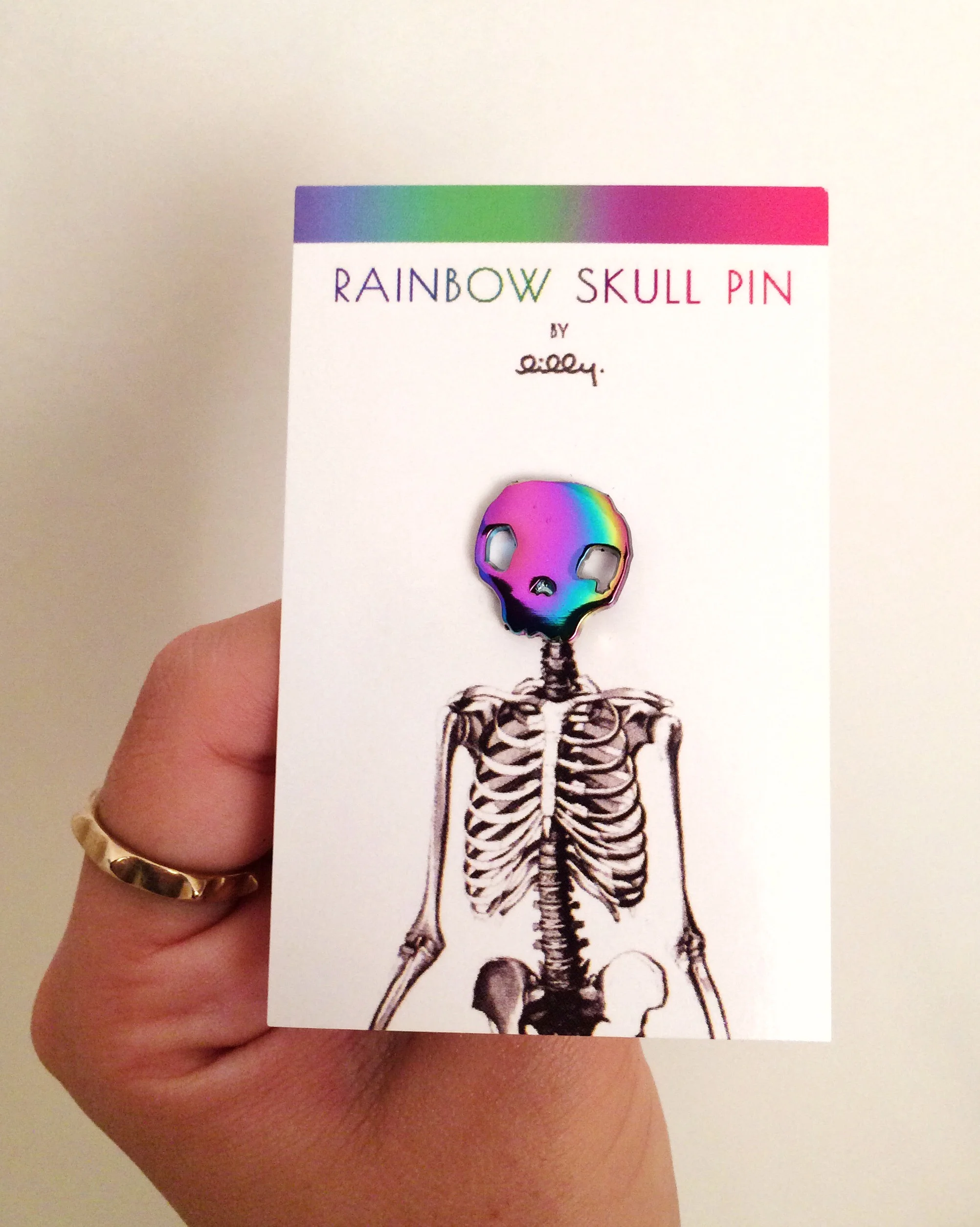 rainbow skull anodized metal enamel oil slick lapel pin originally designed by lilly baik.