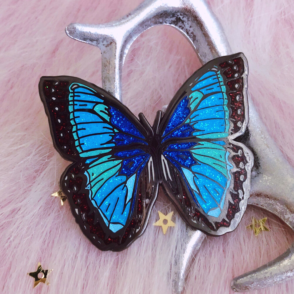 blue butterfly glitter hard enamel pin by lilly baik. — Lilly Baik