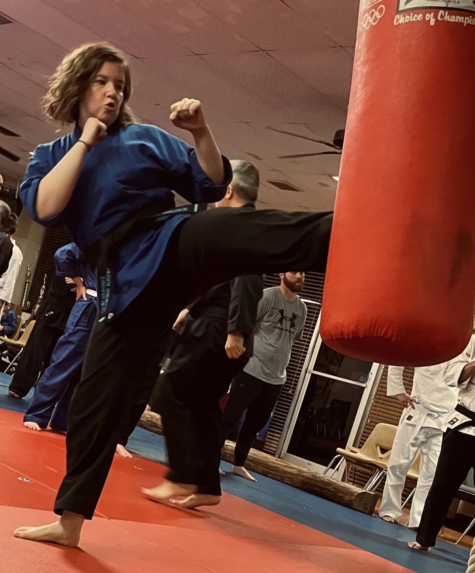 Haley kicking a punching bag at karate