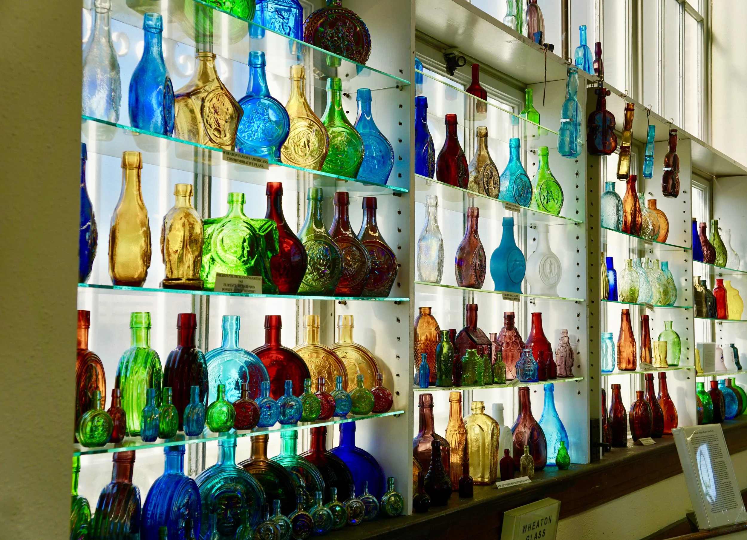 A photo of a wall of historic glass bottles.