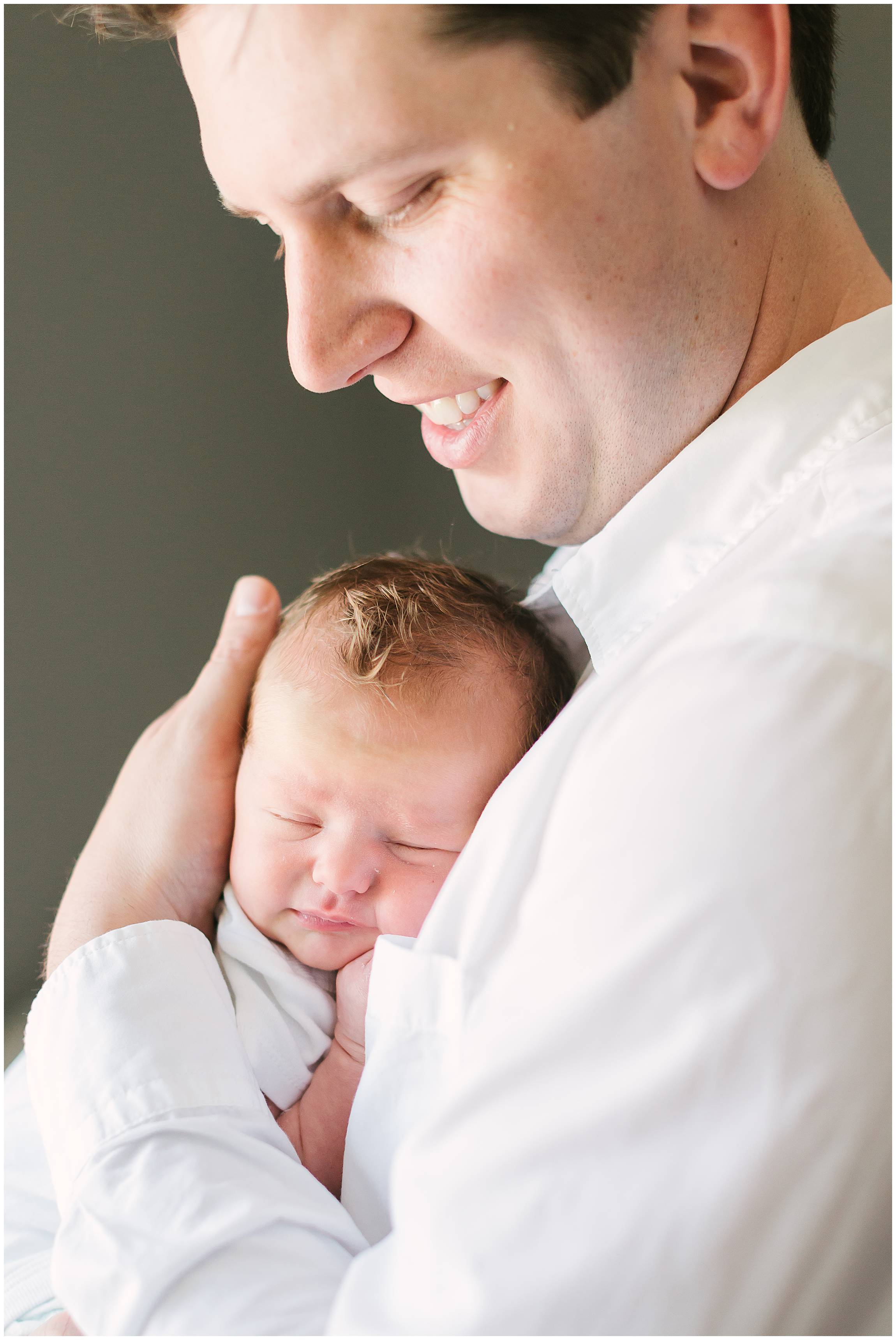 New dad looking at beautiful baby bright and airy
