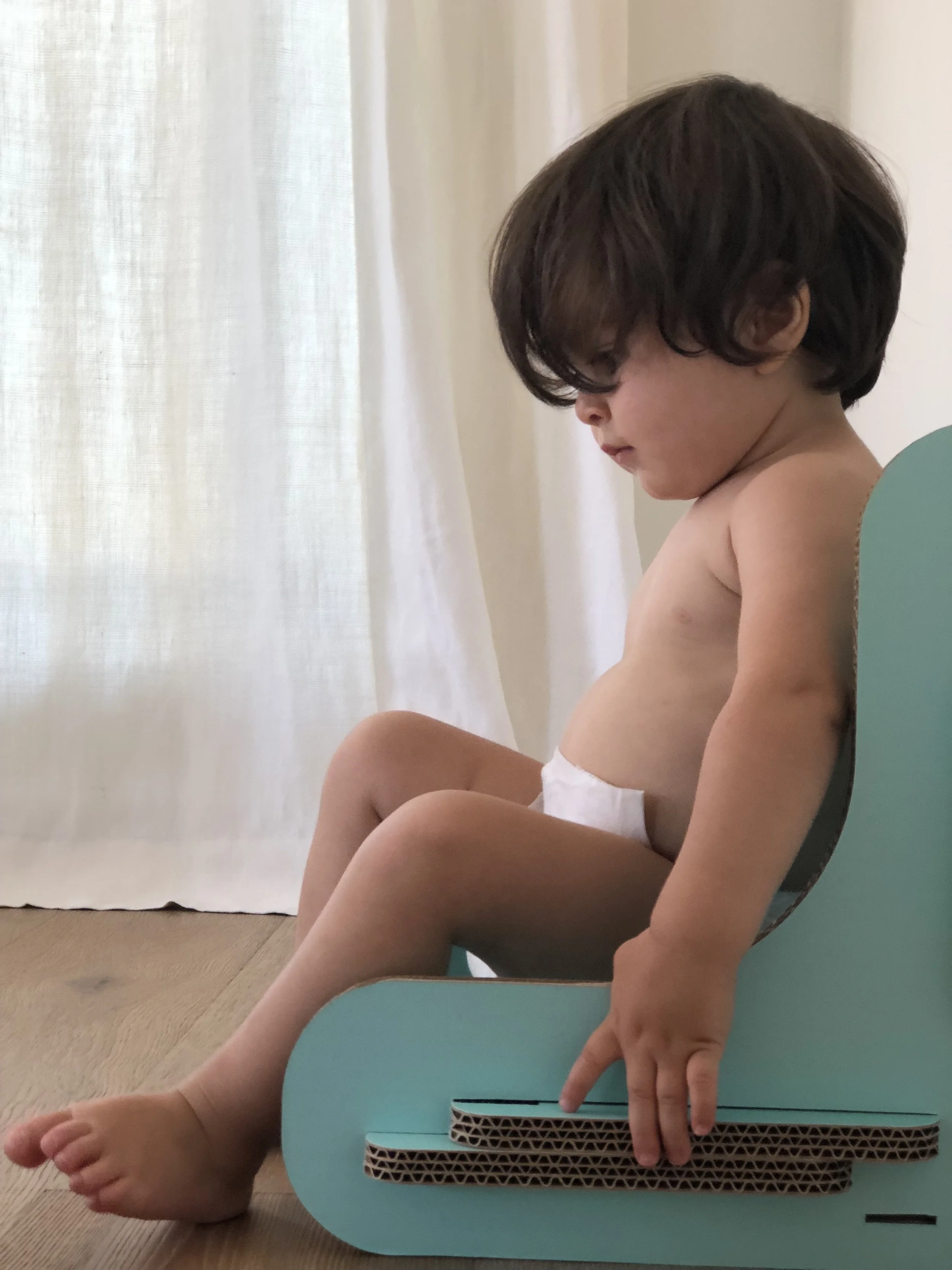 Leo testing out his new uCarton booster while papa assembled.