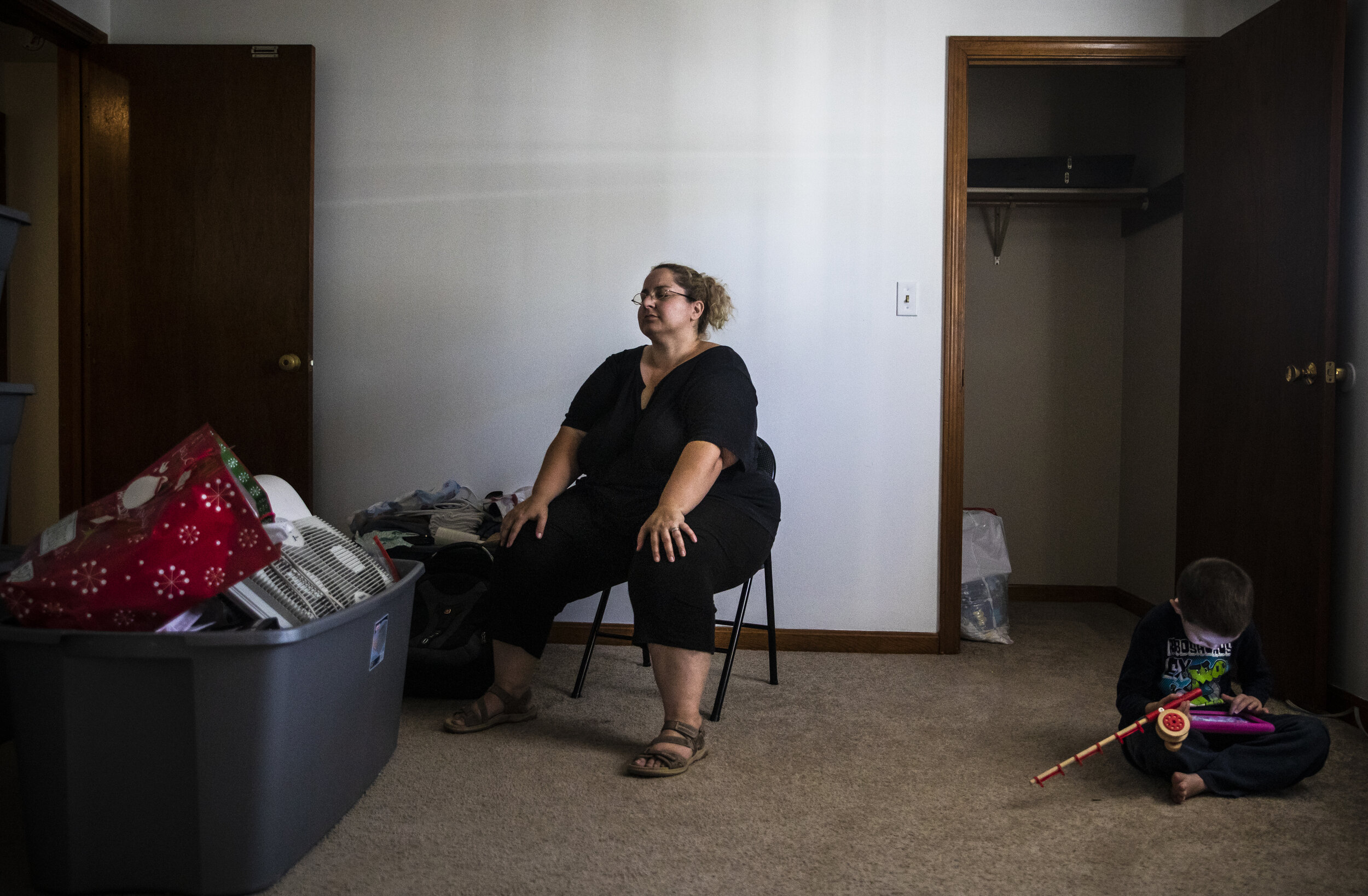 Mariah LeMieux-Lupien closes her eyes after packing a tote in her bedroom while her son Dylan, who has non-verbal autism, sits quietly at her side. The family of five is being forced out of their home
