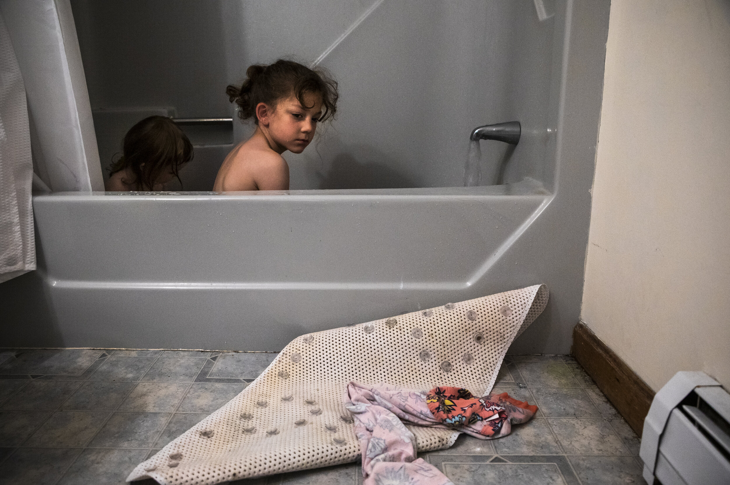 Laya, left, and Evan Lupien take a bath while their parents move out of their three-bedroom apartment in Biddeford, ME. Two years ago, the family moved from Northern Maine to seek out better opportuni