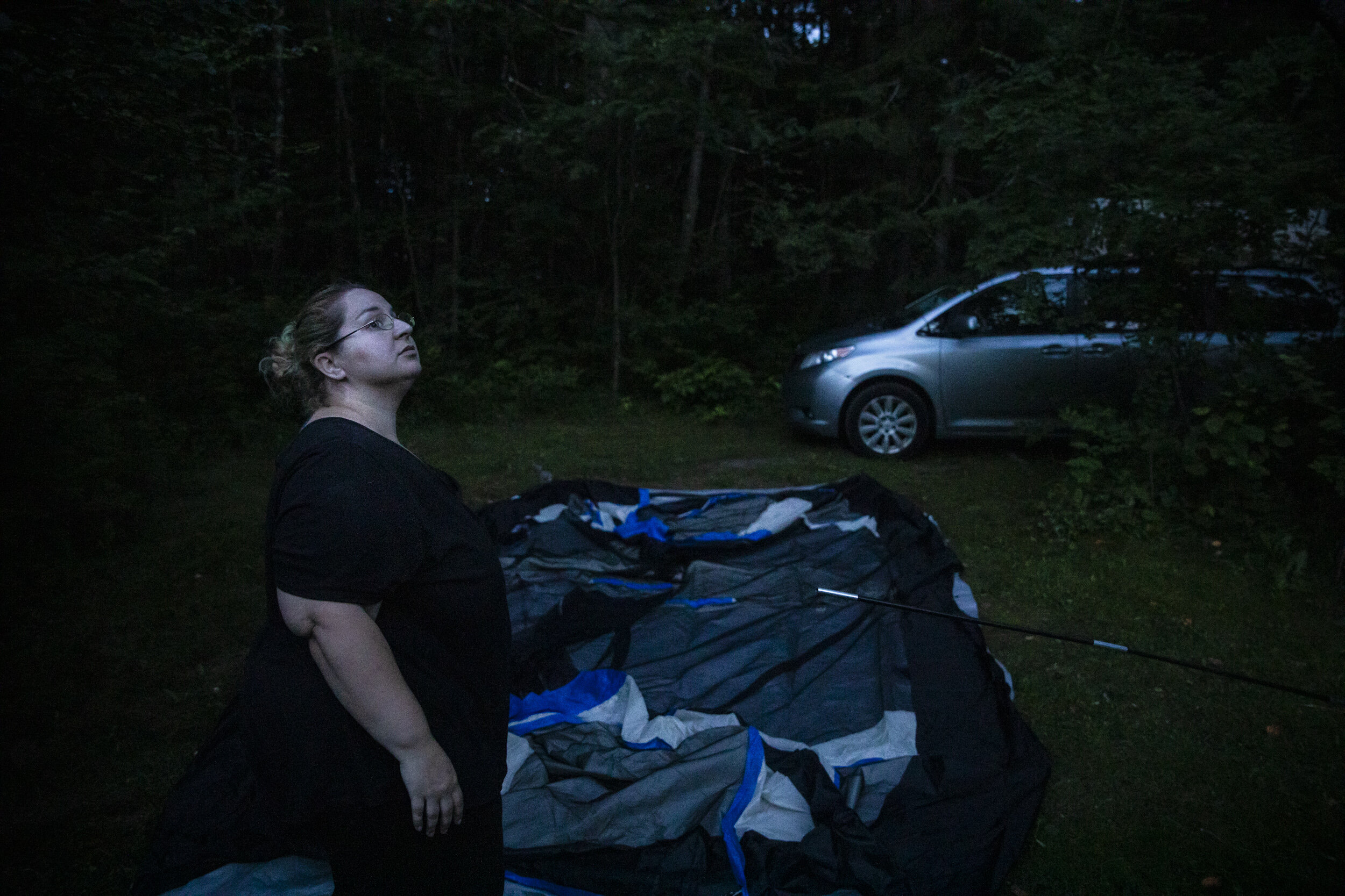 Mariah LeMieux-Lupien  looks at the sky while setting up her family's tent in Shamrock Campground. Faced with eviction, the family of five was forced into a campground for the unforeseeable future.  B