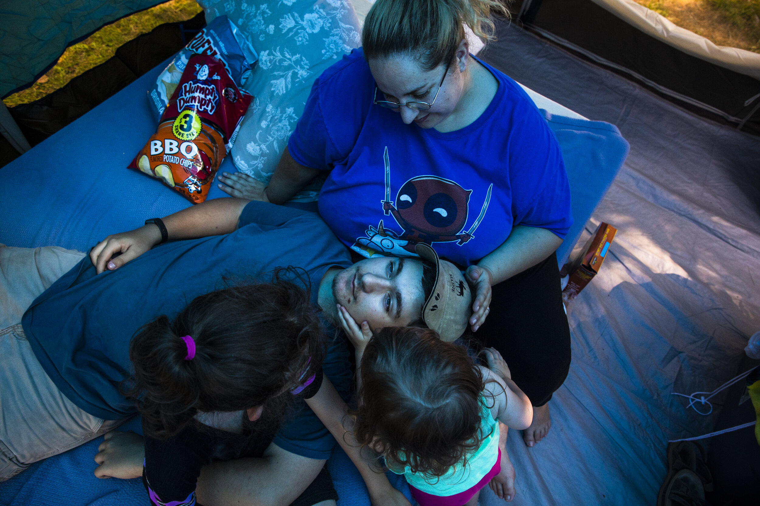  Sam Lupien, Mariah's oldest son, rests his head in his mom's lap while his half-siblings, Evan and Laya curl up next to him. Sam lives in a group home for challenged teens and occasionally visits his