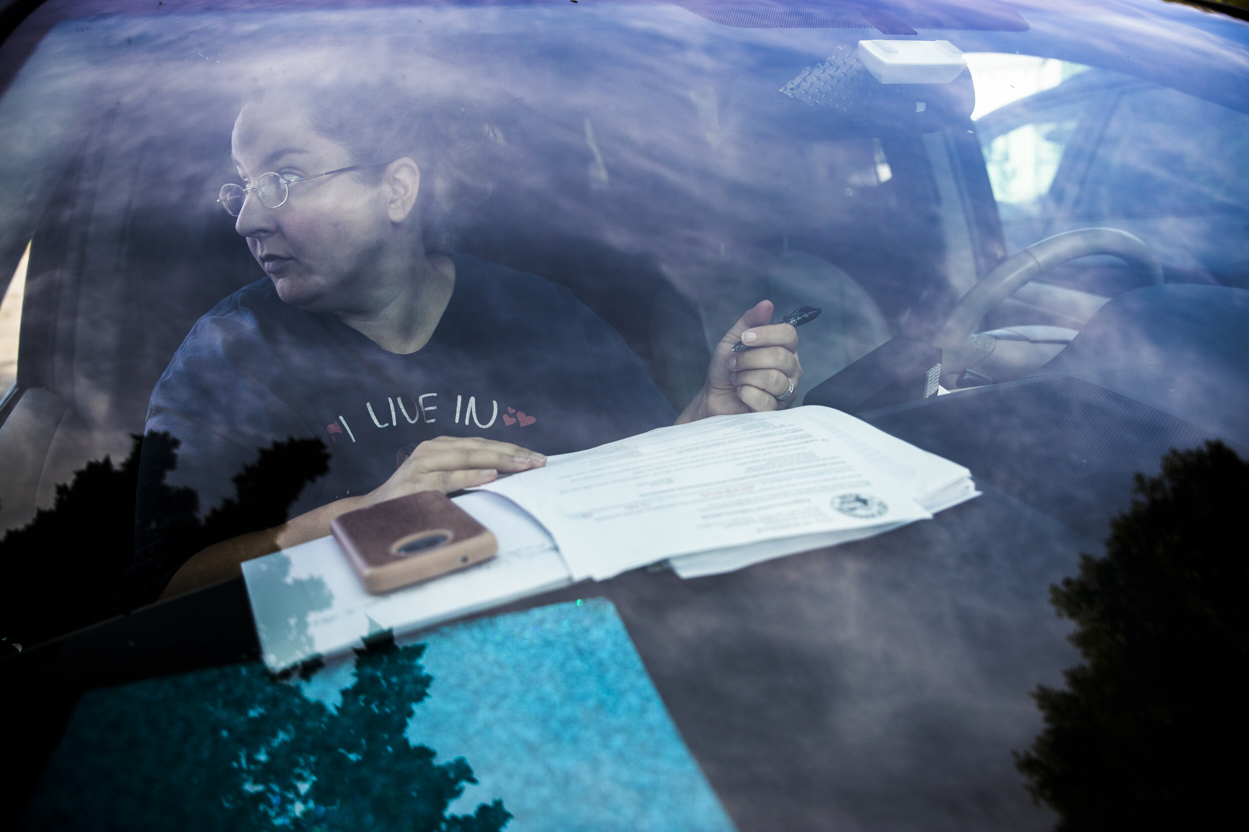 Mariah LeMieux-Lupien sits in the passenger seat of the family's van while filling out application after application for homeless shelters in Maine, Massachusetts, and New Hampshire. While her husband