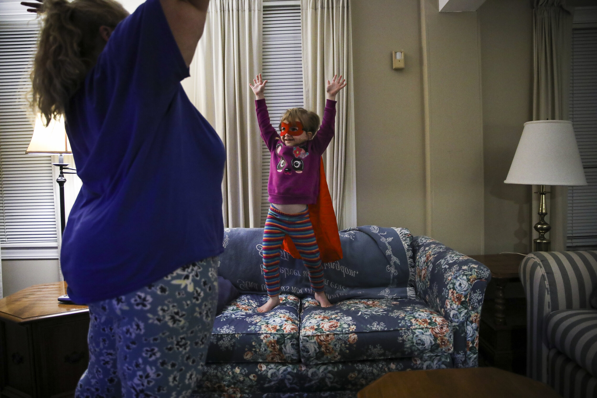 Laya Lupien lifts up her arms in her best superwoman pose while she plays with her mother Mariah during one of their last nights at Seacoast Family Promise. For the past three months, the Lupien famil