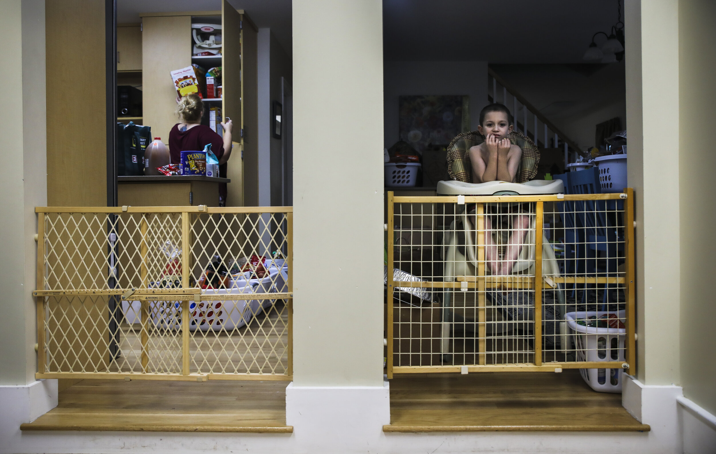 Mariah LeMieux-Lupien  searches for after-school snacks at the Seacoast Family Promise day house while her son Dylan waits in a highchair. For the past three months, the Lupien family has been at Seac