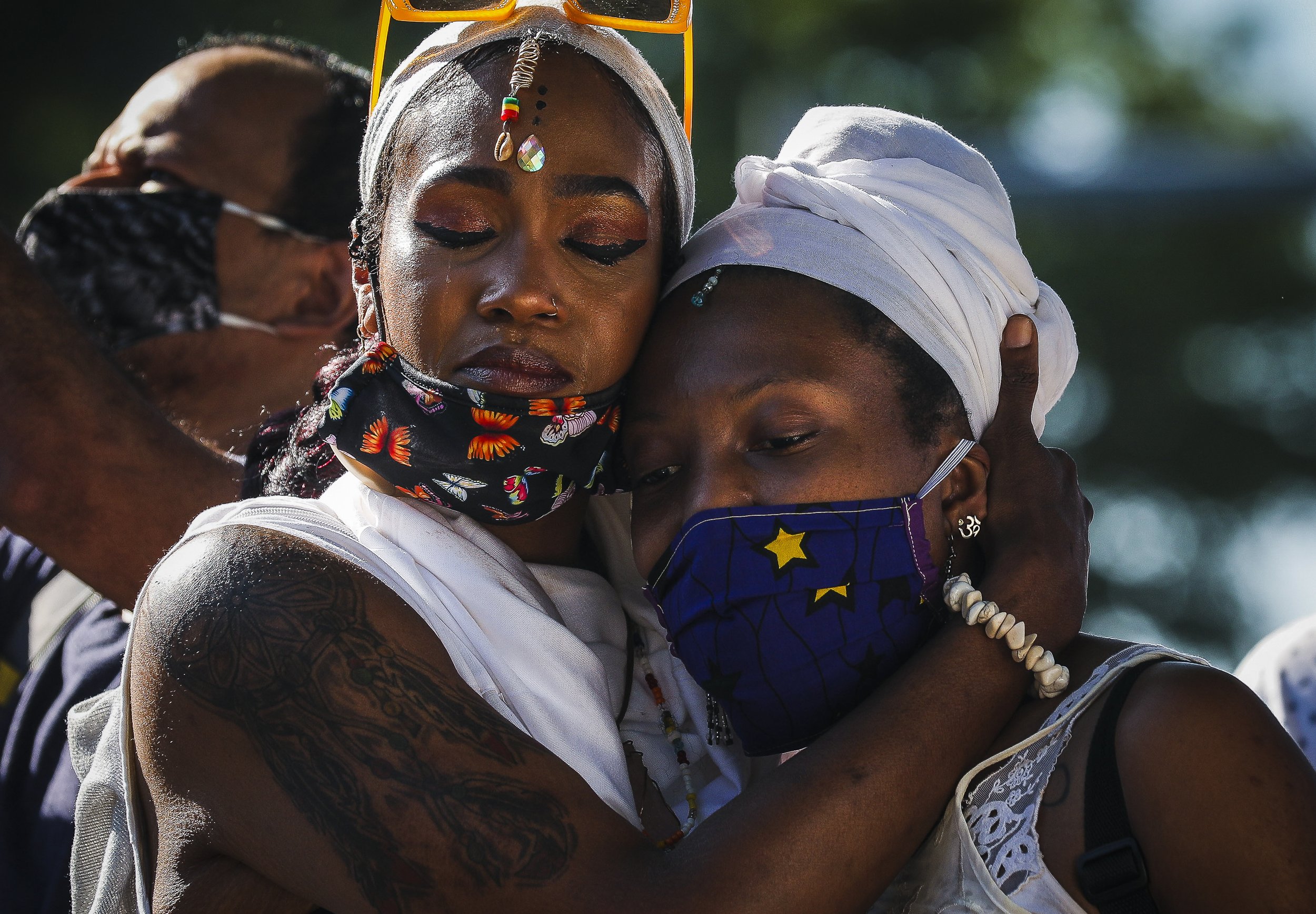   Danielle Ruffen, left, embraces her friend as they hold sacred space for the Black women who have been slain by law enforcement.   More than 1,000 people gather Saturday afternoon to celebrate the lives of Black women and demand an end to police vi