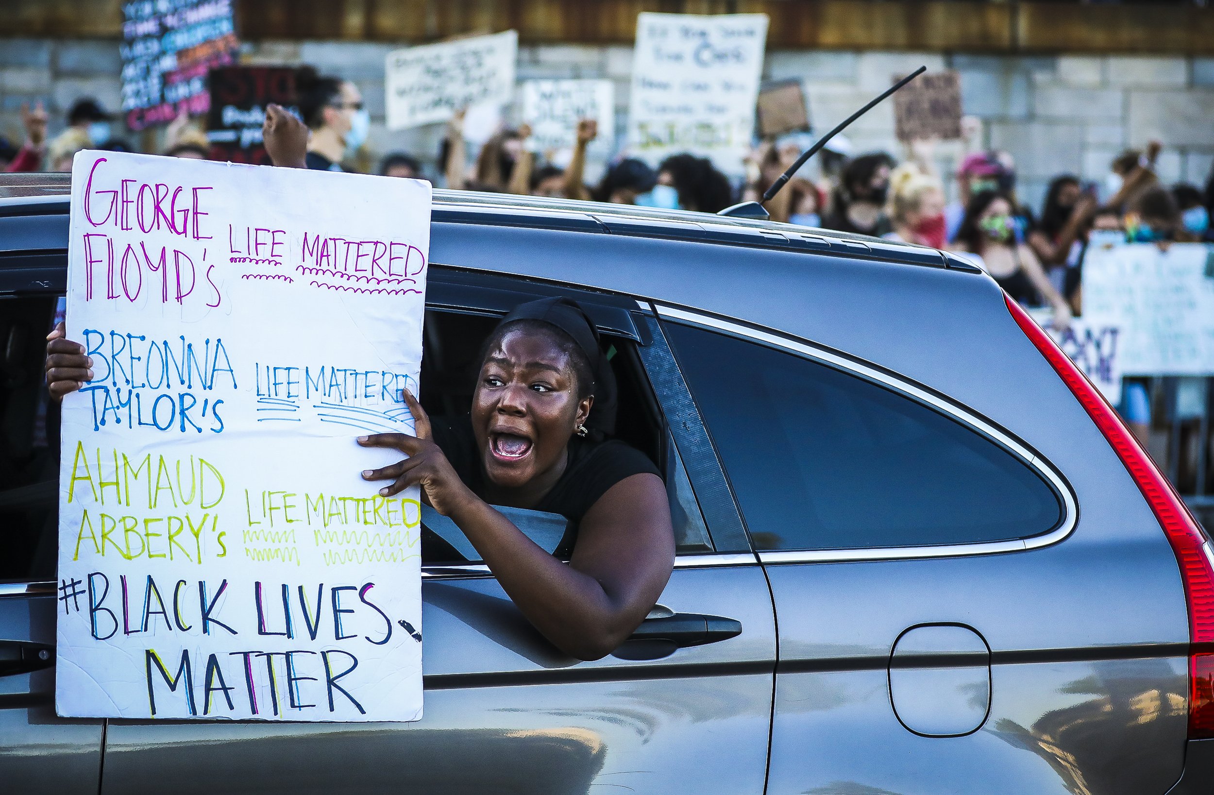  A Black Lives Matter protestor yells out of her car window while looping around the rotary as she joins others in participating in a counter Black Lives Matter Protest. A Law Enforcement and First Responder rally was held in West Roxbury and Black L