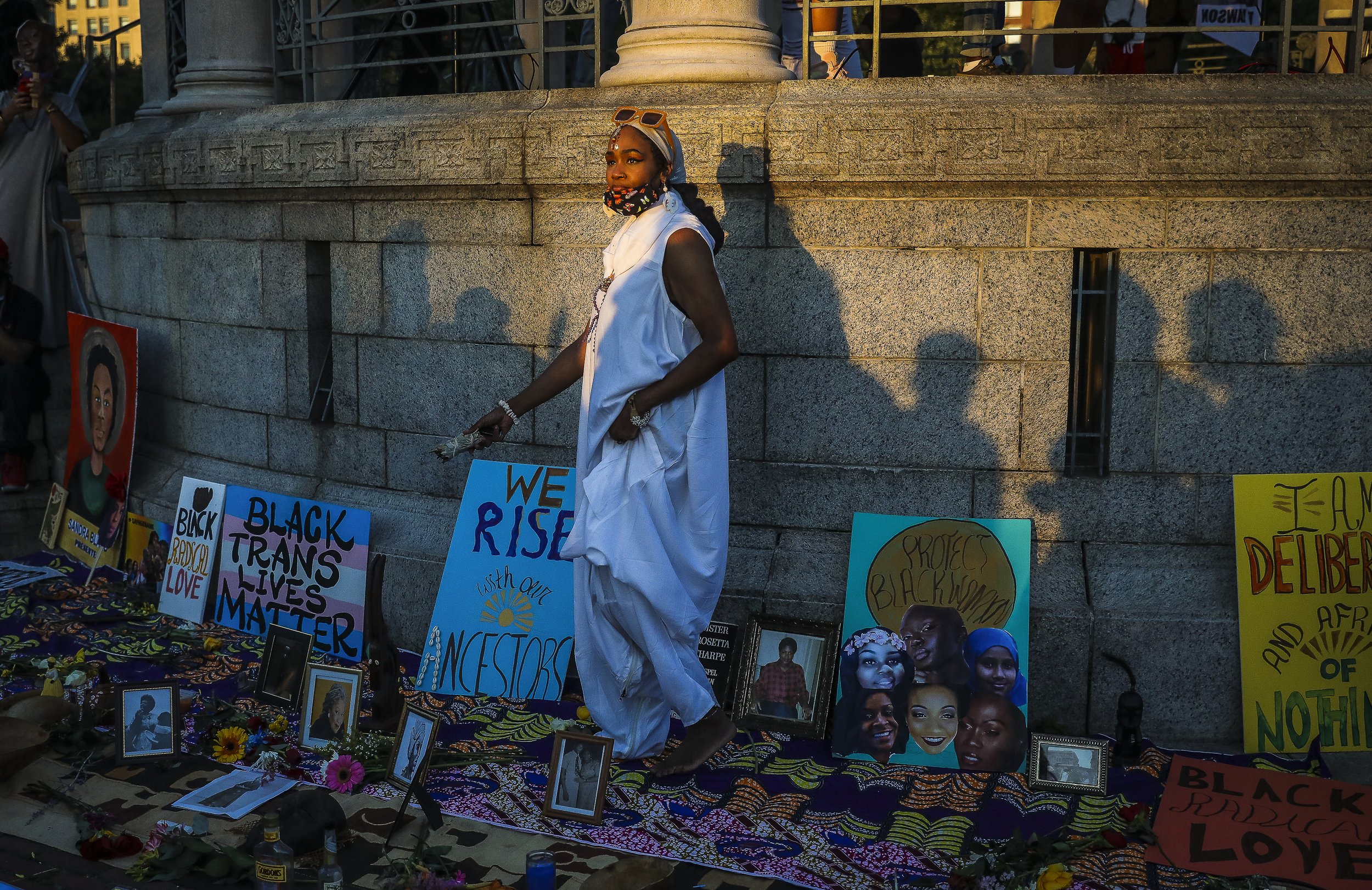  Danielle Ruffen burns sage over a memorial as she joins the Sistahs of the Calabash while they hold a sacred space for the Black women who have been slain by law enforcement.   More than 1,000 people gather Saturday afternoon to celebrate the lives 