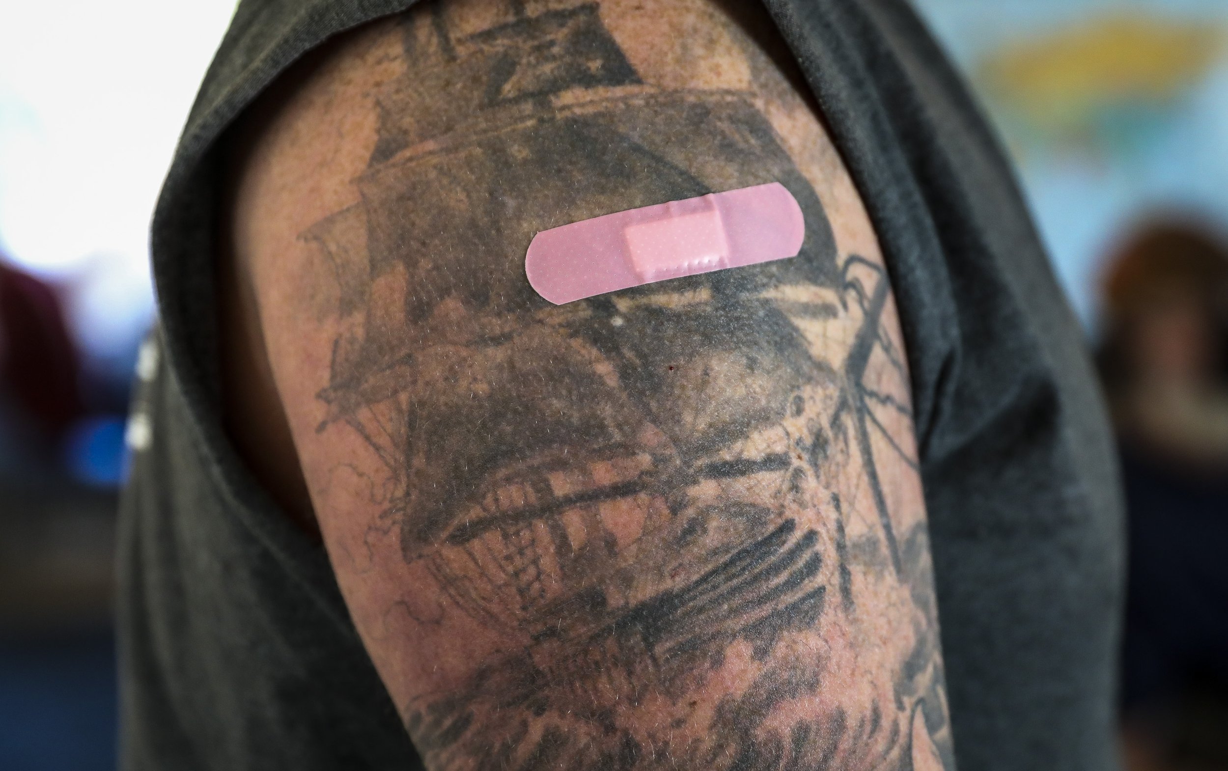  Seth Young receives a vaccine on an arm he had tattooed as an 18-year-old to pay tribute to his island roots. A map of the islands off the coast of Maine wraps around his arm like a treasure map; an X marks Matinicus, where he grew up.   