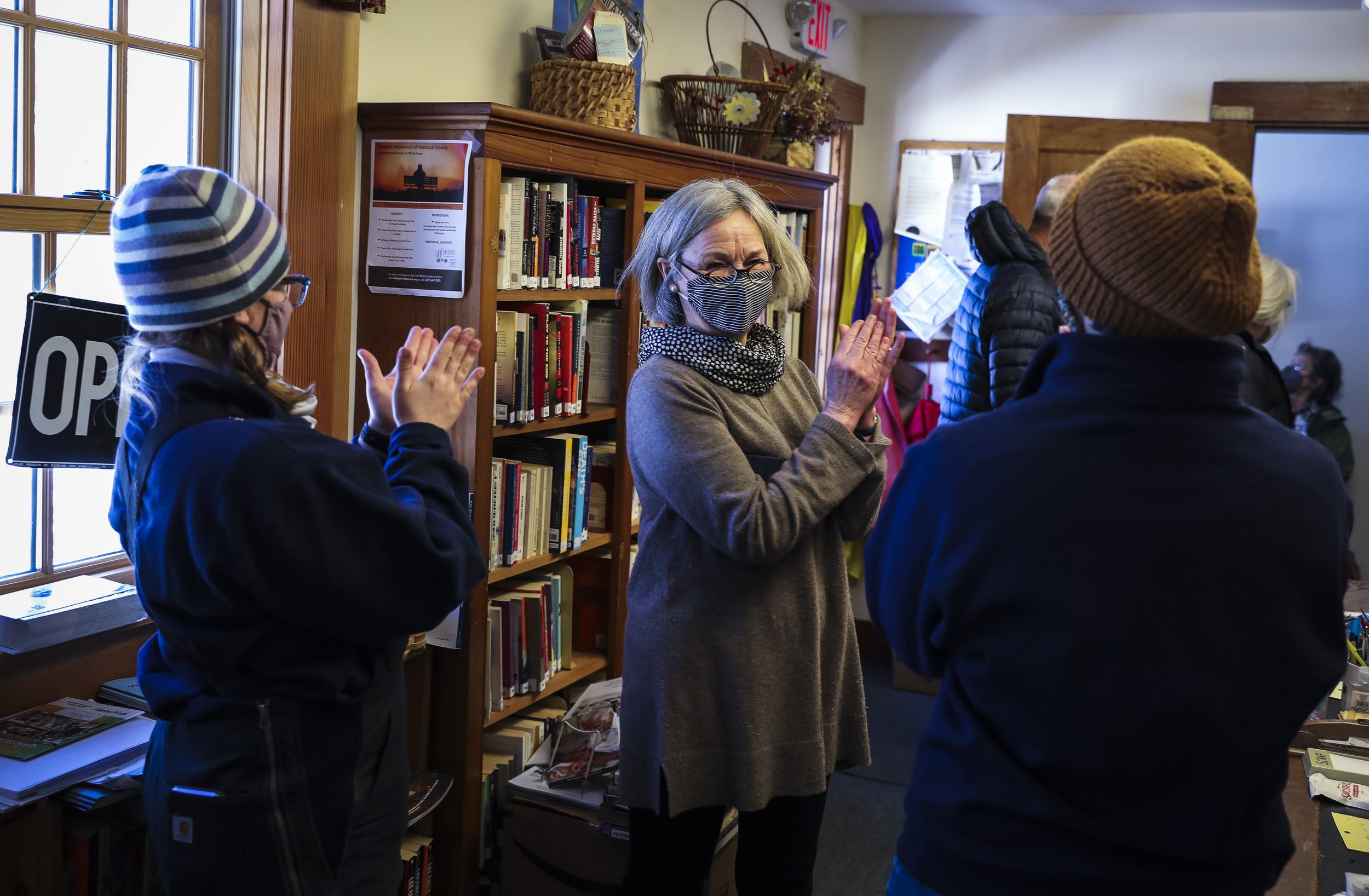  Chief of Cranberry Isles Rescue Service Katelyn Damon, left, Islesford resident Barb Fernald. center, and Assistant Chief of Cranberry Isles Rescue Service Mary Schuch applaud Seacoast Mission staff after they vaccinated islanders on Isleford at the