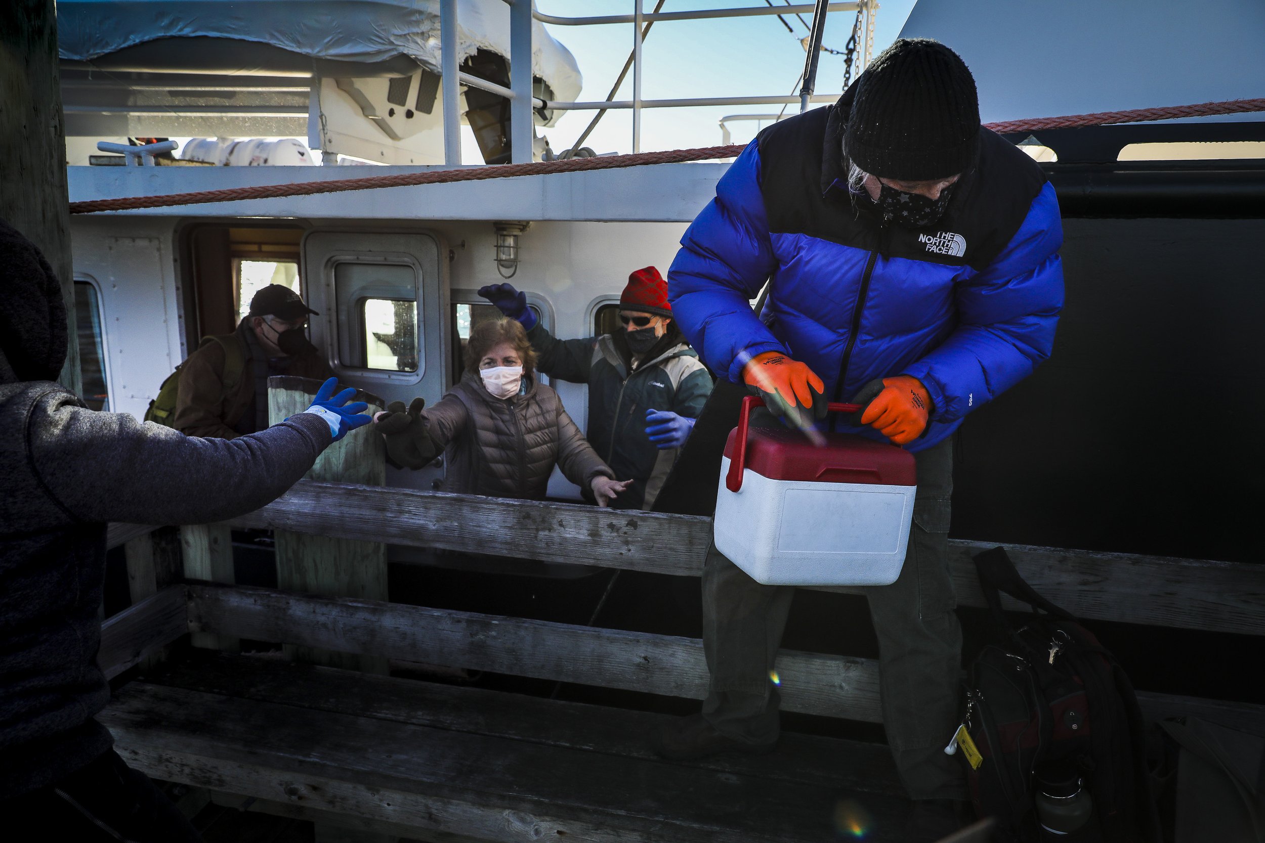  Sunbeam Engineer Storey King takes the vaccine cooler off the Sunbeam as the Seacoast Mission crew arrives at Great Cranberry Island, ME, the crews first stop after leaving their home base of Northeast Harbor on February 26, 2021. From Friday to Sat