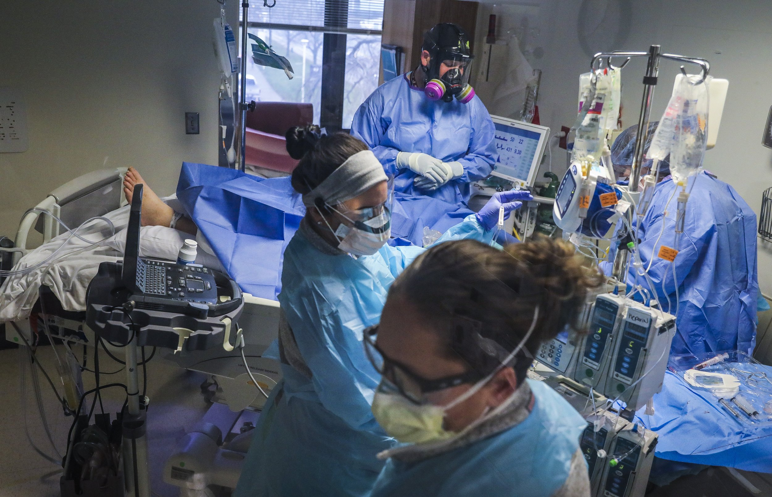  Healthcare workers work together to put in a dialysis line for a patient while working in the COVID-19 Intensive Care Unit at UMass Memorial Medical Center in Worcester, MA on December 29, 2021. As COVID-19 cases spike and the pandemic ravages on, h
