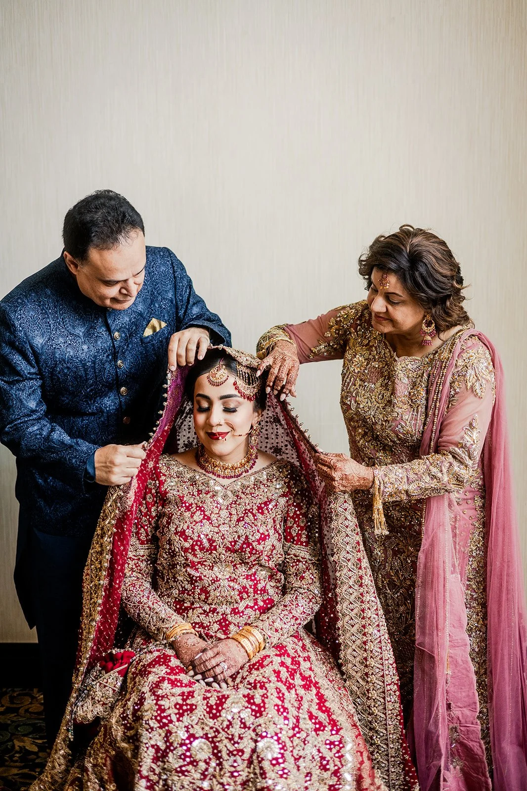 South Asian bride getting help from her parents.