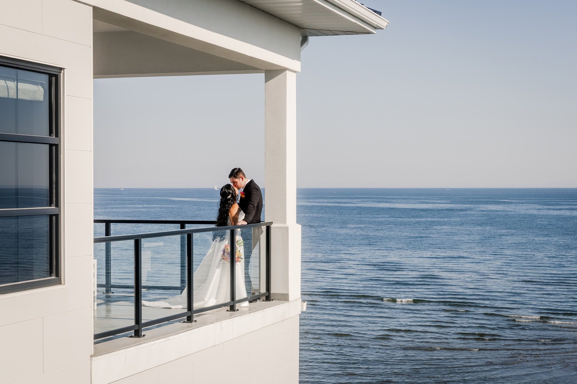Bride and groom kissing on the dance floor at Tyde at Walnut Beach wedding venue.