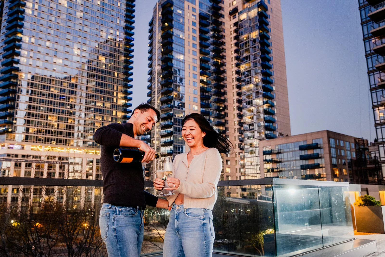 A man pouring champagne after proposing to his girlfriend.