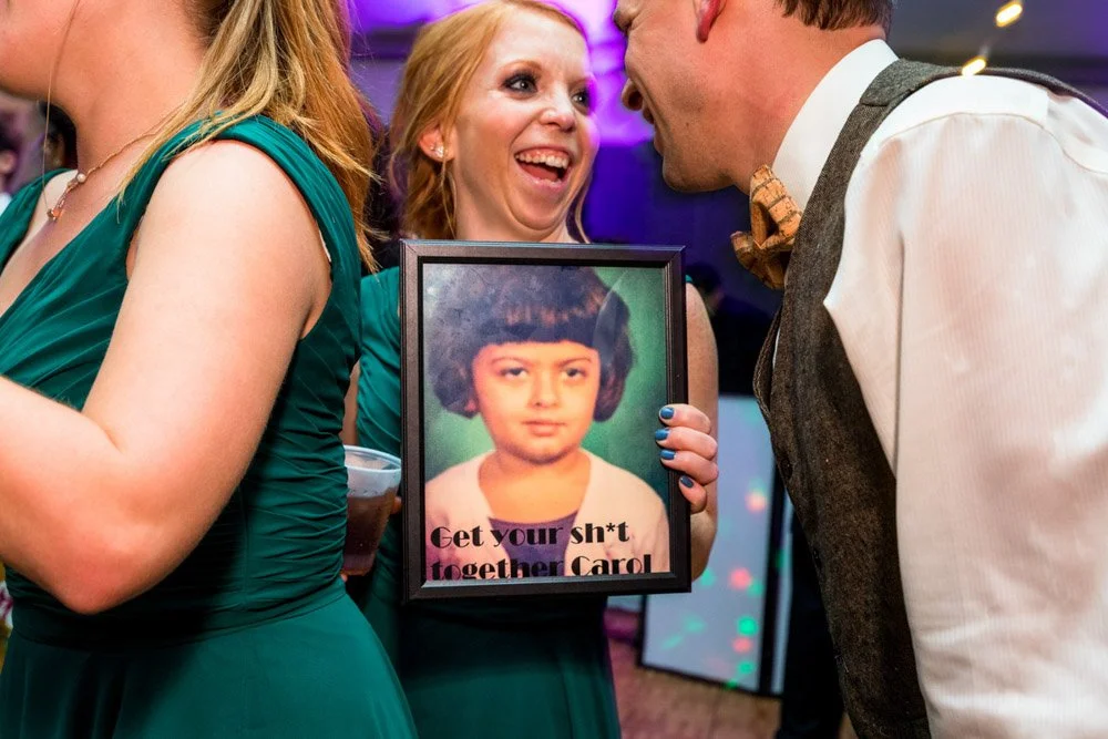 People laughing at a wedding reception.