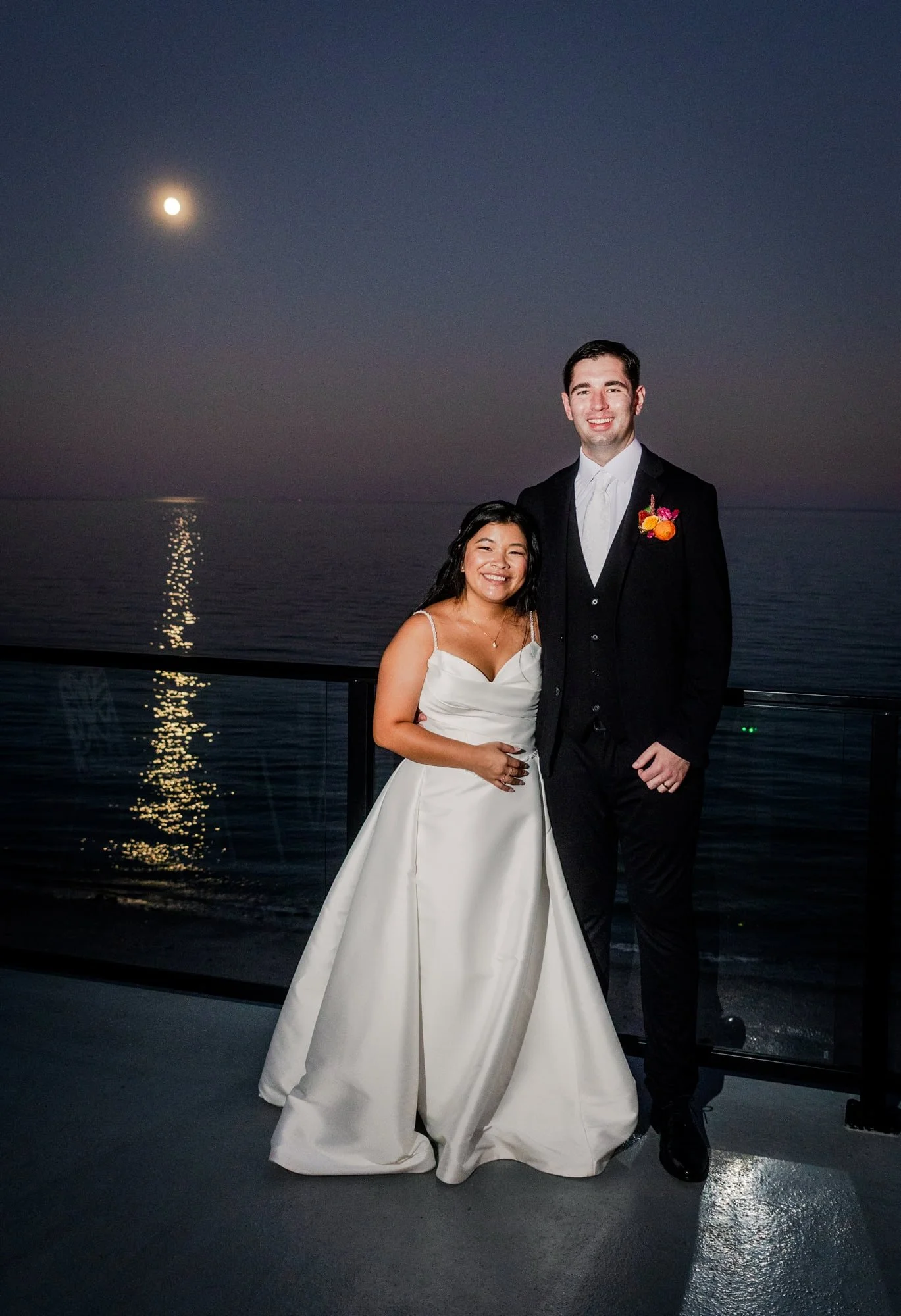 Bride and groom posing on the balcony at Tyde at Walnut Beach.