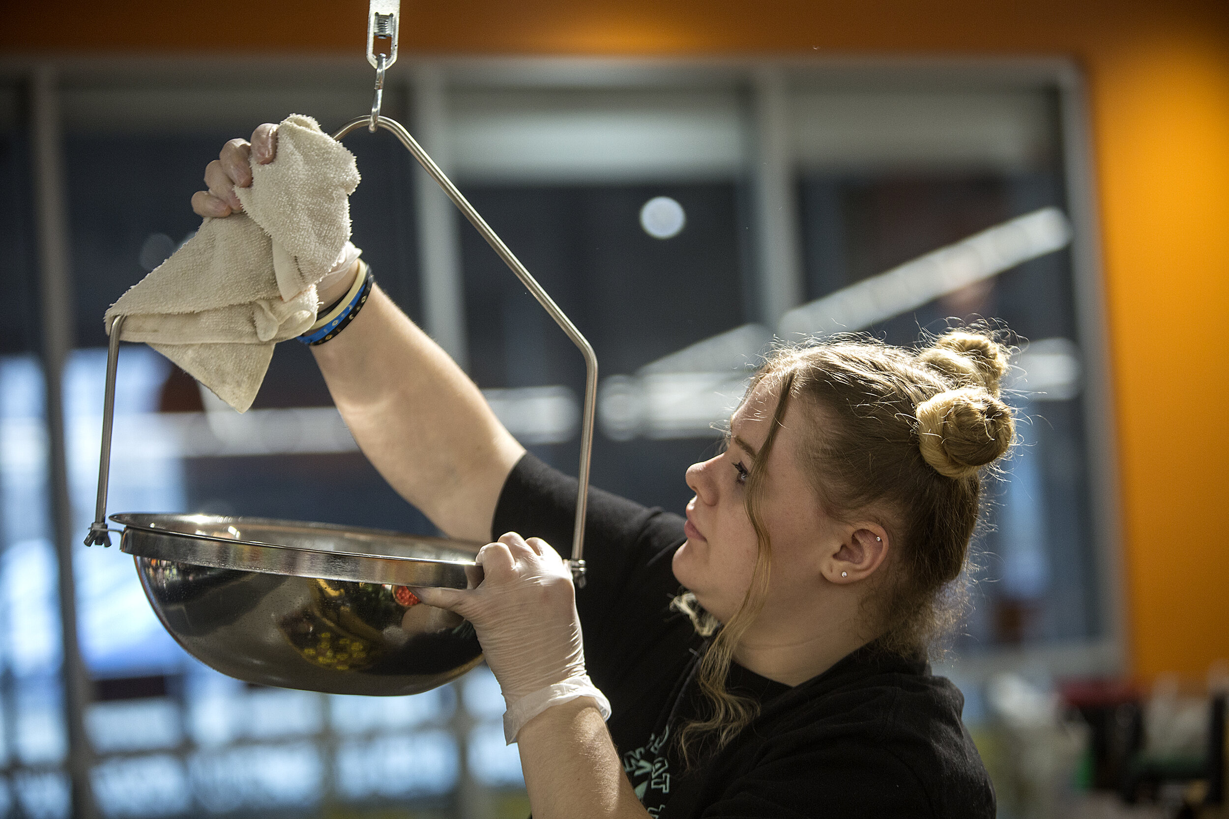 Emily Fridolfson disinfects a produce scale at North Market, which has new cleaning protocols because of the outbreak. Emily and her sister, Marbry, clean surfaces around the store at the top of each hour. It takes about 30 minutes to complete.  