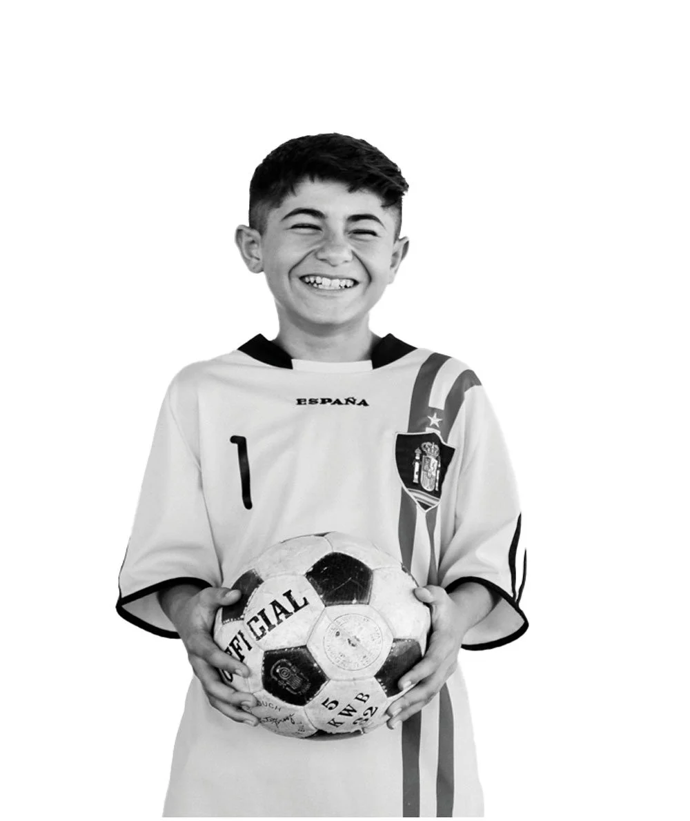 Young refugee holding a soccer ball, representing hope, resilience, and the power of sports to bring communities together while empowering youth in refugee camps to build brighter futures.