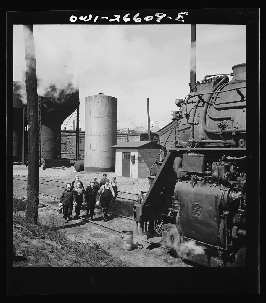 Women wipers of the Chicago and Northwestern Railroad going out to work on an engine at the roundhouse. Source