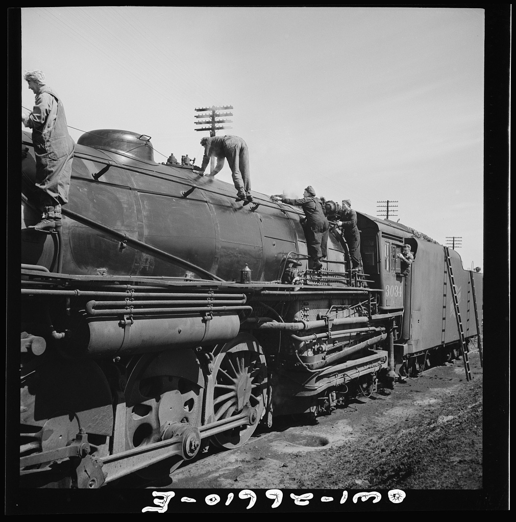 Women wipers of the Chicago and Northwestern Railroad going out to work on an engine at the roundhouse. Source