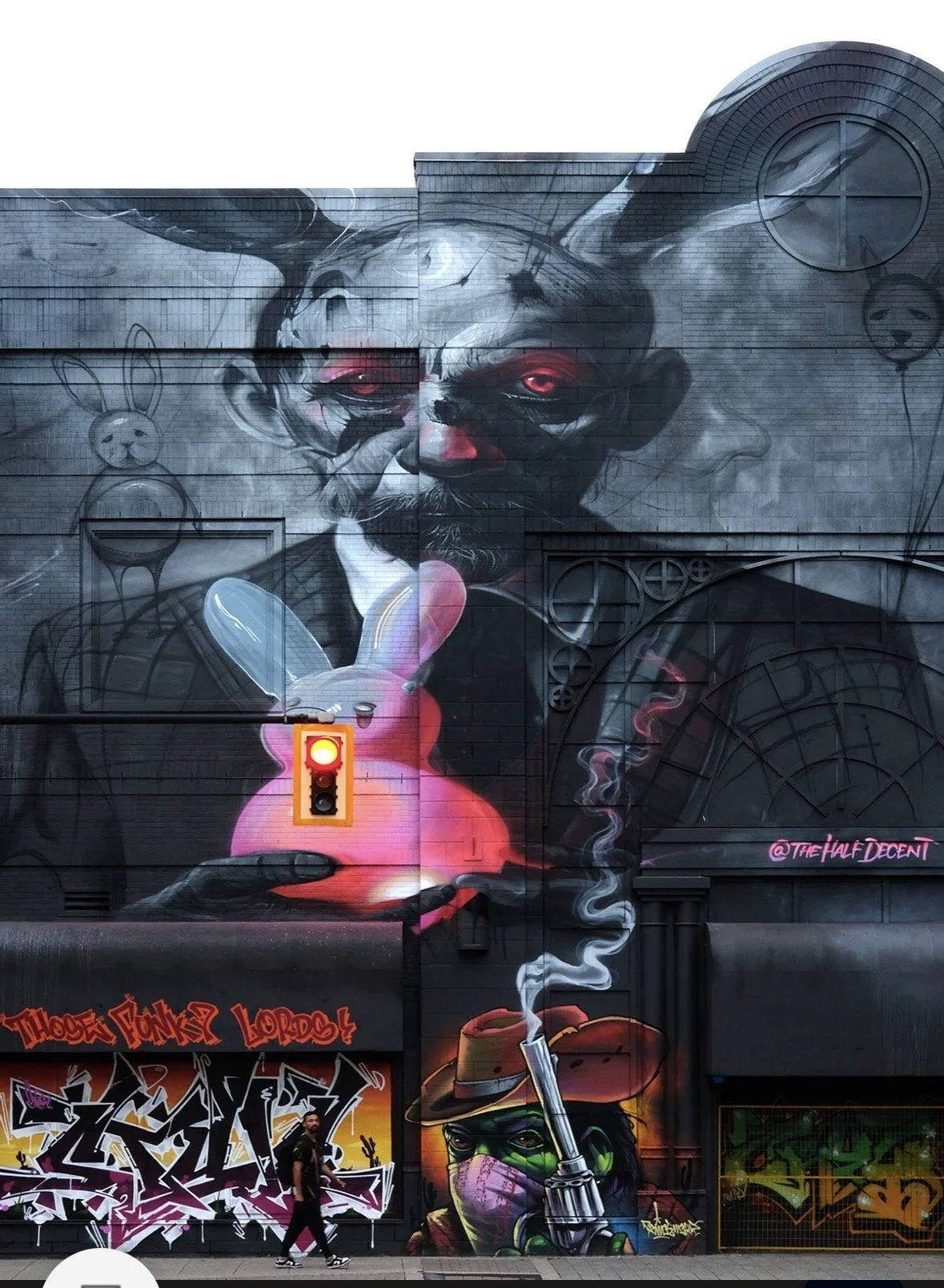 Large-scale street mural with a surreal portrait and pink balloon rabbit.