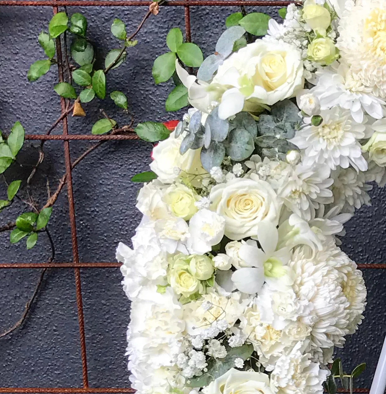 Zoomed image of white seasonal flowers including orchids roses and chrysanthemums.