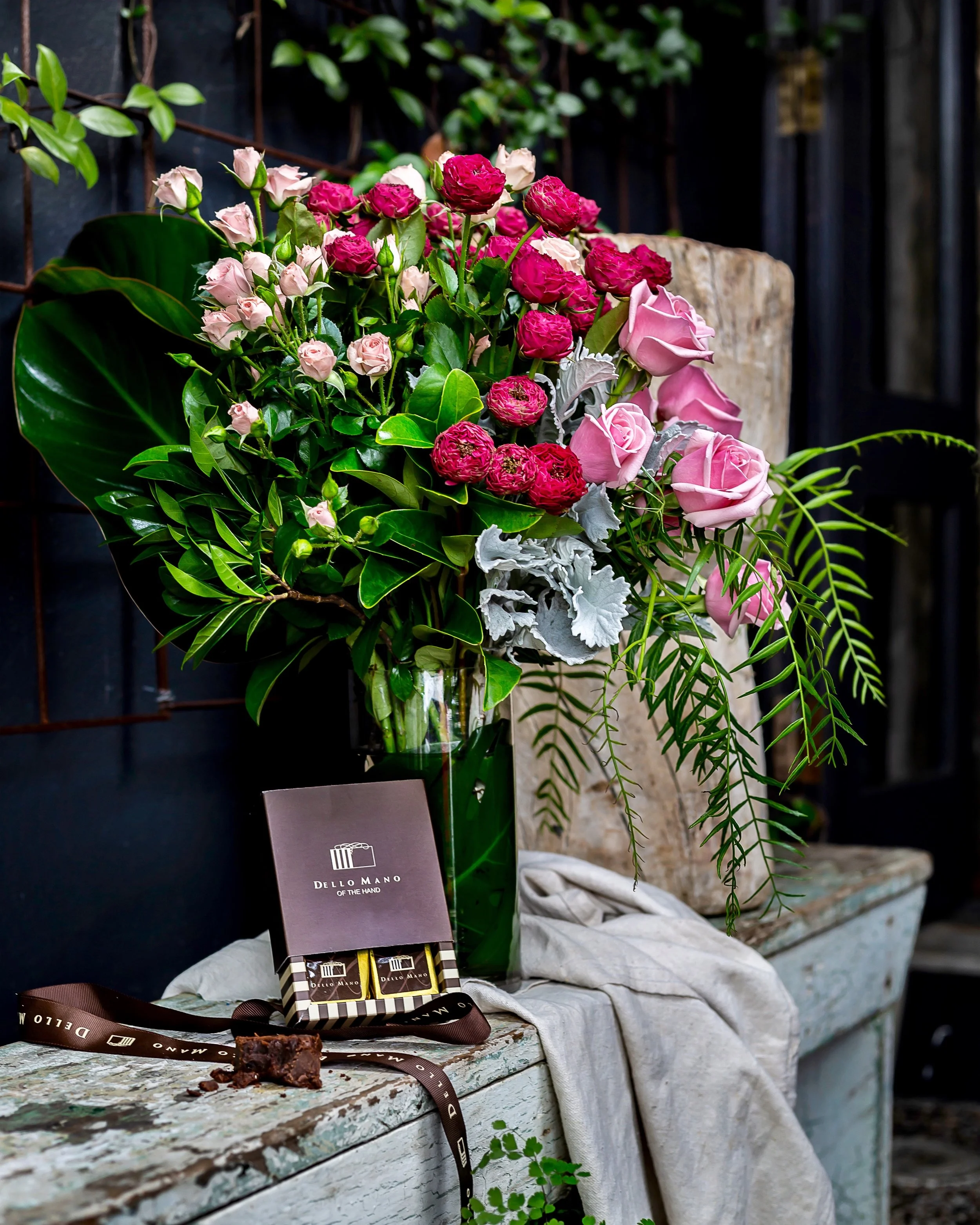 Beautiful vase arrangement of locally grown spray roses and box of Dello Mano brownies.
