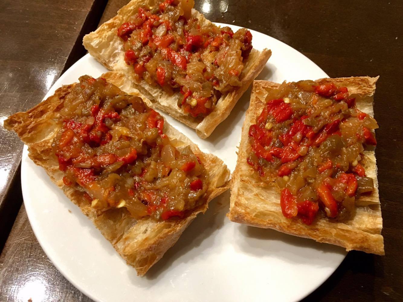  Bread topped with sun-dried tomatoes,&nbsp;sautéed green peppers, and simmered onions 